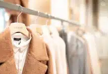 brown coat hanged on white plastic hanger